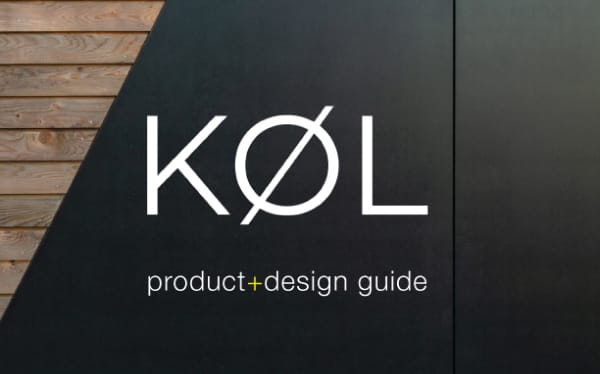 The image shows "KØL product+design guide" in white font on a background split vertically, with the left side having a textured wooden surface and the right side a plain dark surface. The 'O' in "KØL" has a slash through it, evoking an industrial feel akin to sheet metal or Exterior Facade Cladding.